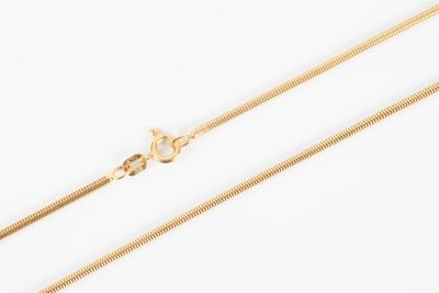 a close up of a gold chain on a white background