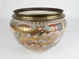 a gold and white vase with a lid sitting on a table