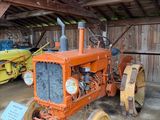 deux vieux tracteurs dans une grange, avec une pancarte devant eux