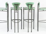 three green stools sitting next to each other on a white surface