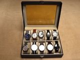 plusieurs montres dans un coffret posé sur une table au plateau en bois