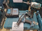 une perceuse sans fil et deux autres outils posés sur une table