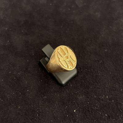 a picture of a gold signet ring on a black surface