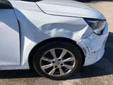 a white car that has been damaged and is parked in a parking lot