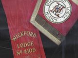 a red and gold ribbon with a picture of a lion on it