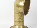 an antique brass pipe on a wooden base on a white background