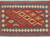 a red, blue and green rug with a diamond design