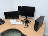 a desk with two monitors and a keyboard on it
