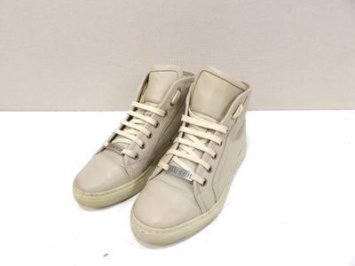 une paire de baskets blanches à lacets posée sur un fond blanc