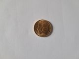 a small gold coin on a white surface