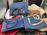 a pile of purses and handbags sitting on the floor