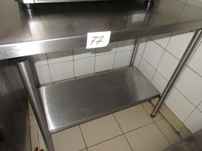 une table en acier inoxydable sur laquelle est posé un micro-ondes