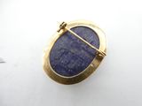 a close up of a lapel pin with a blue stone in it