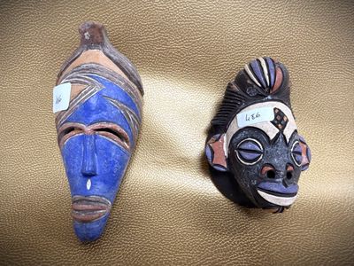 two masks that are sitting on a brown surface