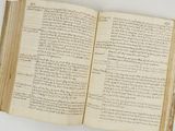 un vieux livre ouvert, sur lequel on peut lire des mots, posé sur une table