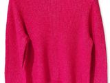 un pull rose sur un cintre, sur fond blanc