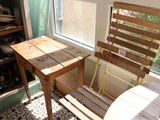 une table et une chaise en bois dans une pièce dotée d'une fenêtre