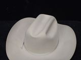 a white cowboy hat sitting on a black surface