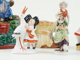 five figurines of people and a bird on a table