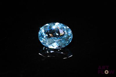 a close up of a blue diamond on a black surface