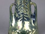 a silver vase that is sitting on a table