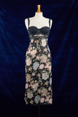 une robe posée sur un mannequin, devant un fond bleu
