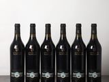 six bouteilles de vin sont alignées sur une table en bois