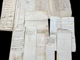 several old papers are stacked on top of each other on a black surface