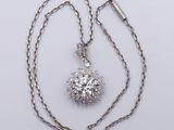 a close up of a diamond necklace on a chain on a white surface