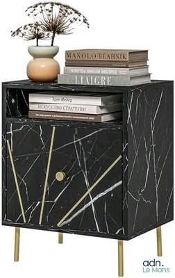 une commode en marbre noir sur laquelle sont posés des livres et un vase