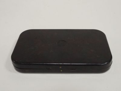 the back of a black cell phone sitting on top of a white table