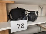 un appareil photo et un sac posés sur une étagère dans un magasin