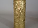 a gold vase with a bird on it on a table