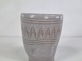 a gray cup that has a wavy design on it