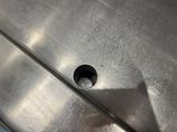 a metal sink with a hole in the middle of it