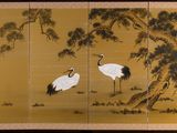 two cranes standing under a tree in a field next to a tree