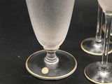 three wine glasses sitting on a table with gold rims
