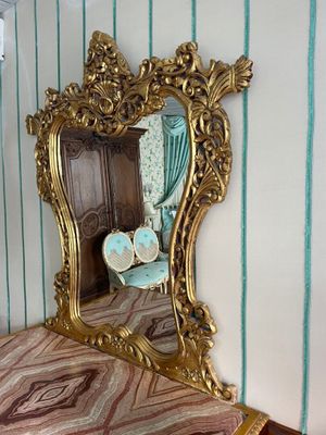 a mirror on the wall above a dresser in a room