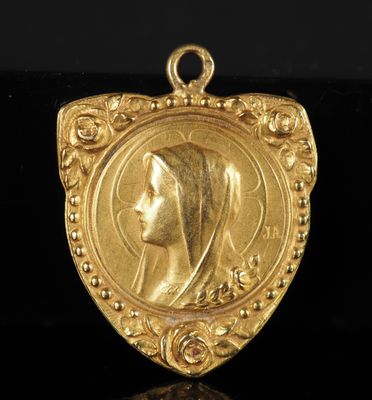 un pendentif en or orné d'une tête de femme au centre