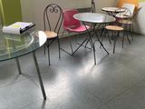 tables and chairs in a room with a large window and a wall mural