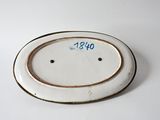 a white plate with a brown rim on a white table