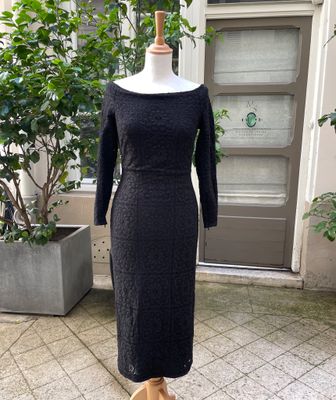 black dress on a mannequin stand in front of a door