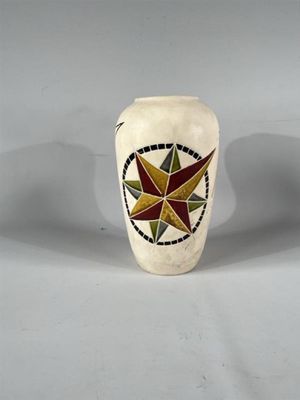 un vase blanc orné d'un motif en forme d'étoile