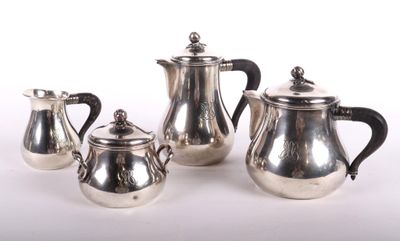three pieces of silver tea and coffee set on a white surface