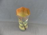 a small vase with a tree on it on a table