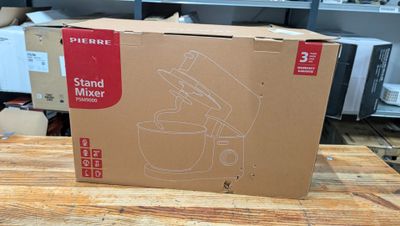 le carton d'un robot pâtissier est posé sur une table en bois