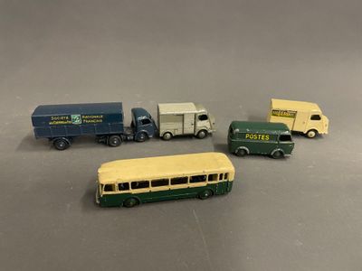 quatre camions miniatures et un bus posés sur une table