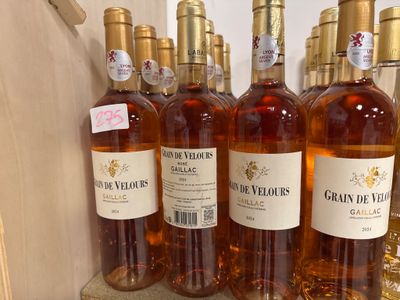several bottles of wine are lined up on a shelf in a store