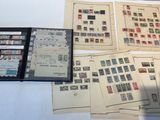 beaucoup de timbres posés sur une table, sur laquelle se trouve un classeur