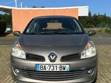 l'avant d'une voiture argentée garée sur un parking à côté d'un immeuble